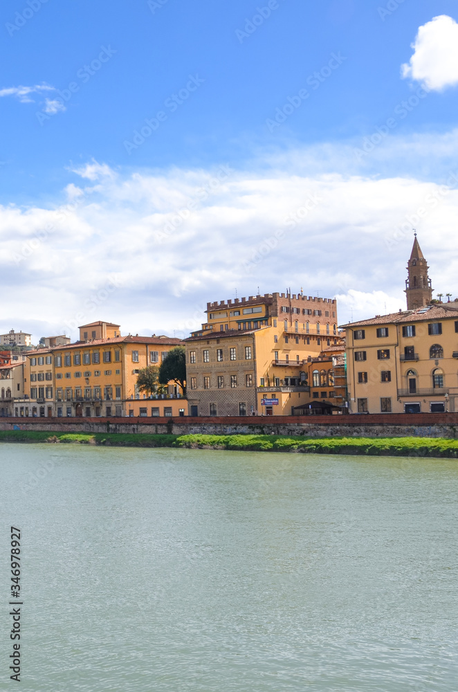 Cityscape of Florence, Tuscany, Italy. Historical center located along the Arno river. Blue sky and clouds over the Italian city. Vertical photo.