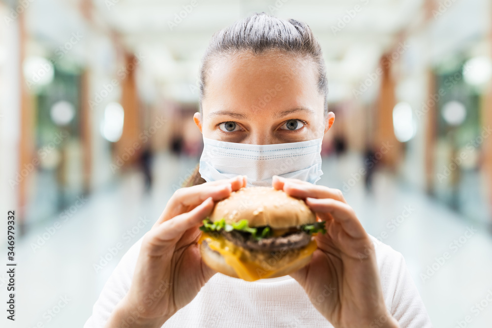 Woman Eating Fastfood Burger In Face Mask Woman Eating Fastfood Burger In Face Mask