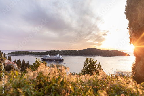 View of the Adriatic sea with Lokrum island and a big cruise ship with tourists near Dubrovnik Old Town in Dalmatia on a sunny day in summer during sunset. Holiday destination  idyllic scenery