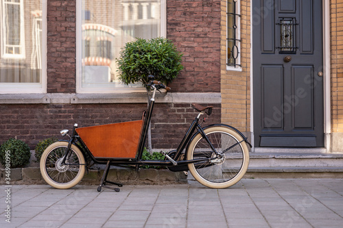Typical dutch carrier bicycle parked in front of a house. Modern urban parents use these carrier bikes to transport their children or groceries