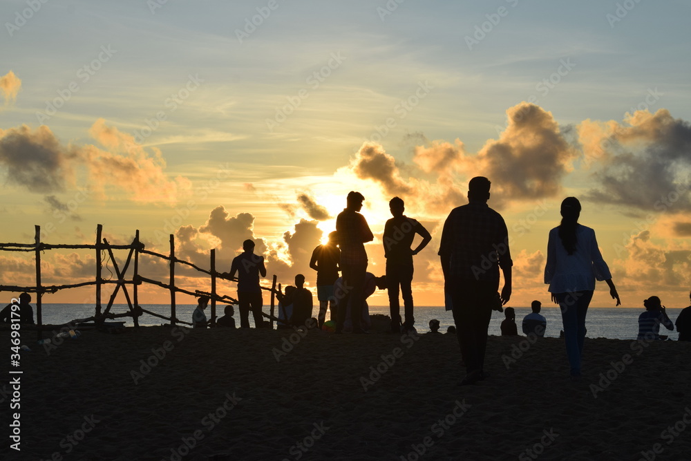 group of people walking on sunset IN BEACH