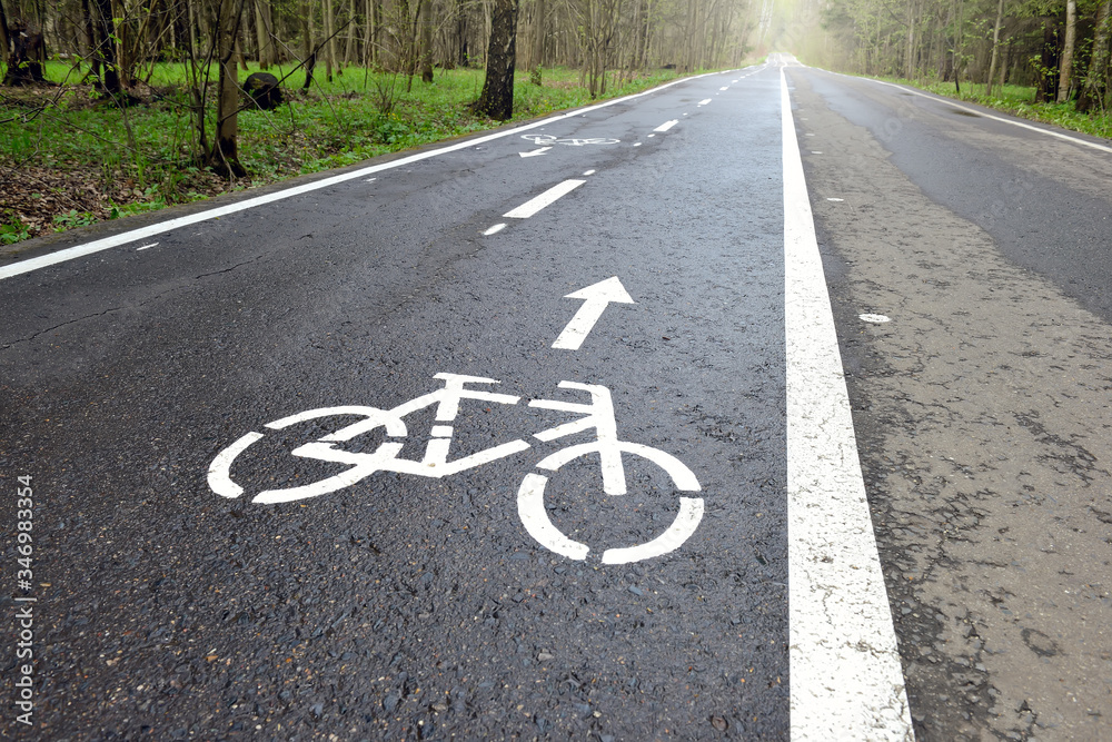Bicycle lane signage on a street. Bicycle path in the summer forest Bicycle lane signage on a street. Bicycle path in the summer forest