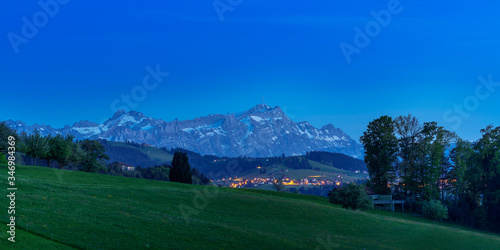 Alps in the evening sky behind a beautiful little illuminated village