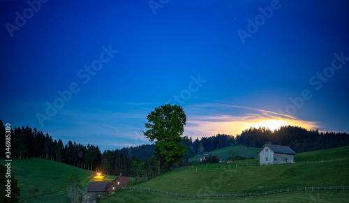 moonlight over rural farm with glowing tractor