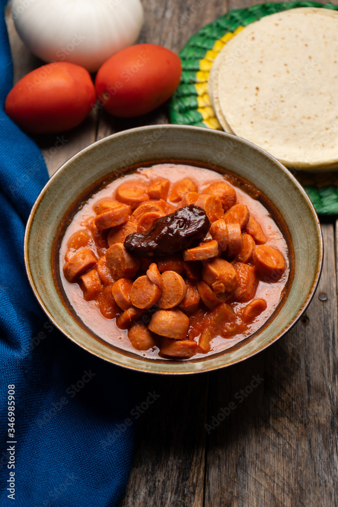 Mexican sausage with chipotle sauce on wooden background Mexican sausage with chipotle sauce on wooden background