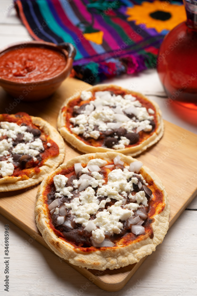 Mexican red sopes with cheese and beans on white background Mexican red sopes with cheese and beans on white background