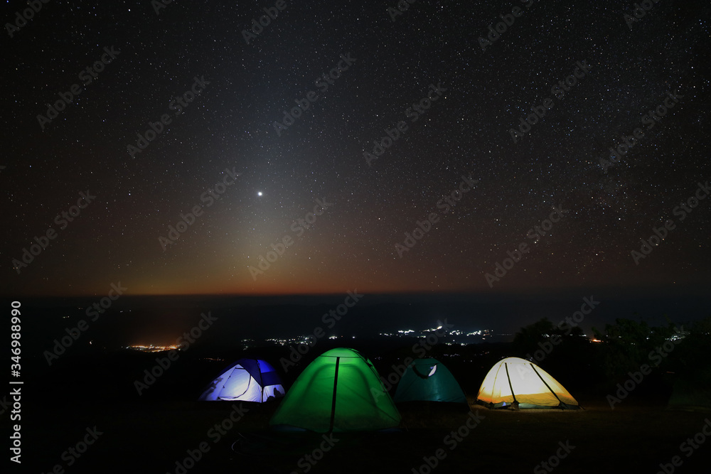 Camping under dark sky with shining stars