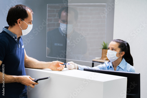 Client Handing Over Credit Card To A Cashier photo