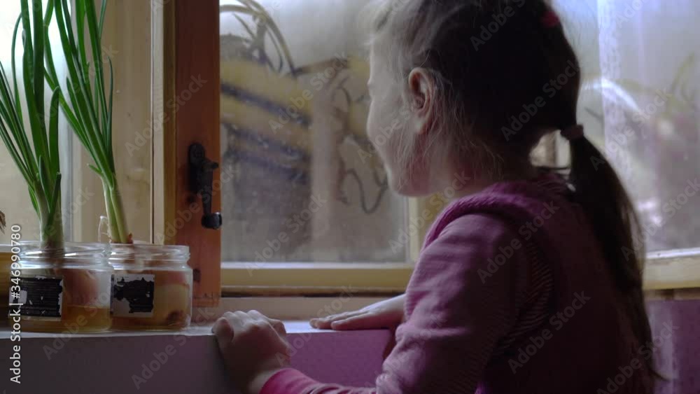 Child at the window. Little girl drawing on the window glass. Child at the window. Little girl drawing on the window glass.