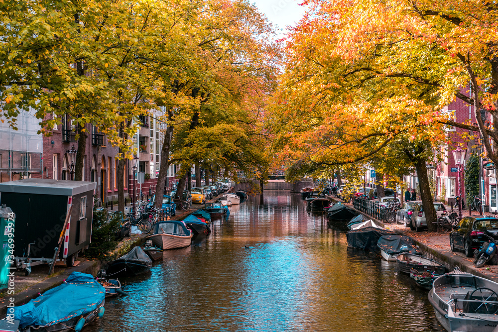 Beautiful Amsterdam neighbourhood with boats along the streets in the canal.