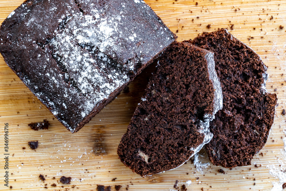 Chocolate cake cut into pieces on a wooden table. Homemade chocolate sweet dessert. Bake at home. Recipe of homemade pastry.