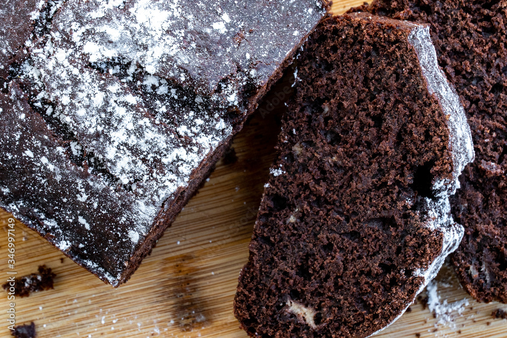 Chocolate cake cut into pieces on a wooden table. Homemade chocolate sweet dessert. Recipe of homemade pastry. Bake at home. Top view close up