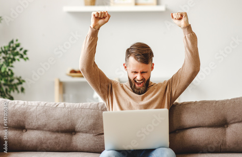 Delighted young  man celebrating victory in online lottery.