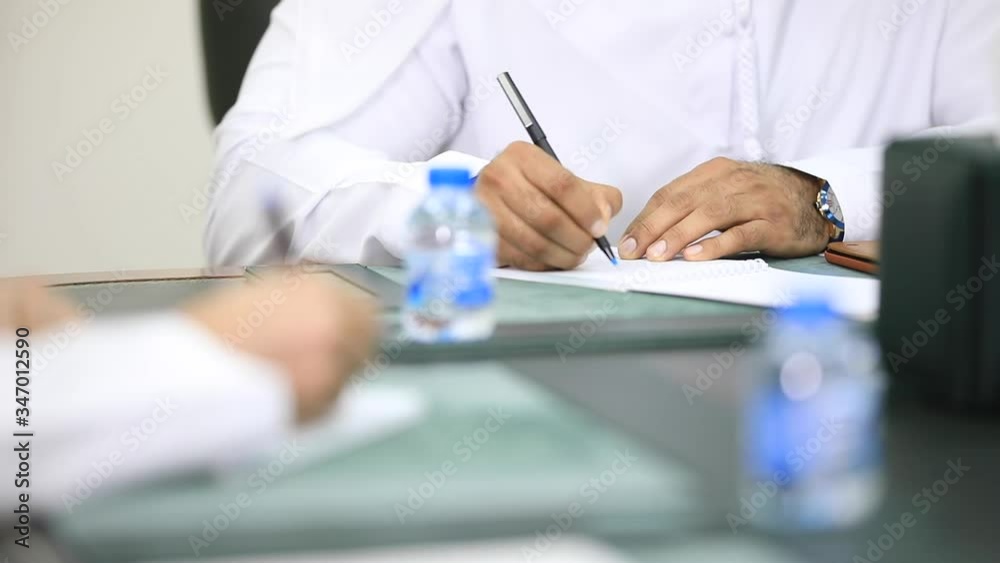 Arabic male hands writing on a piece of paper. Writing essay or letters. Doing homework
