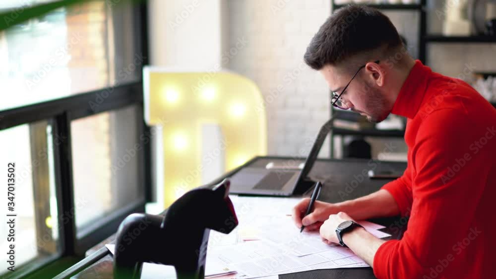 Smart young man dressed in eyeglasses checking informational data on paper documents and writing down text for development of business startup.Pensive hipster guy working remotely at home interior
Smart young man dressed in eyeglasses checking informational data on paper documents and writing down text for development of business startup.Pensive hipster guy working remotely at home interior