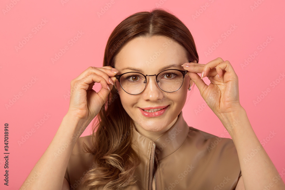 beautiful young woman in glasses on a pink background beautiful young woman in glasses on a pink background