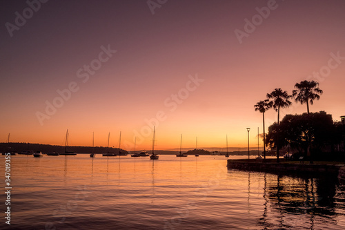 orange dawn and yachts on the water