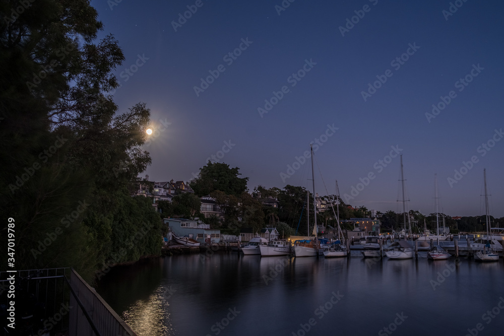 full moon and moored yachts