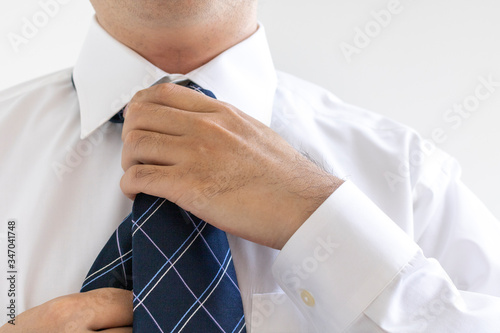 ネクタイを結んでいる、ワイシャツを着た男性