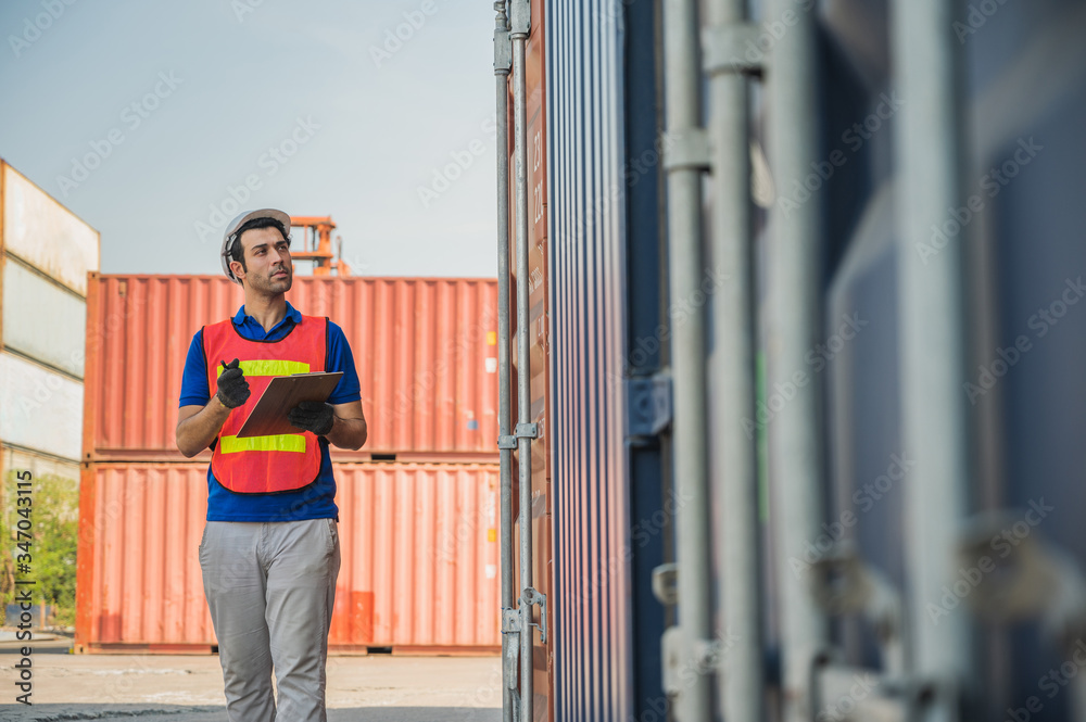 Foreman holding clipboard working at Container cargo harbor. Business Logistics import export shipping concept. Foreman holding clipboard working at Container cargo harbor. Business Logistics import export shipping concept.