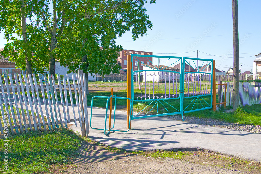 rotating gate in the fence on the sidewalk