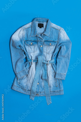 Denim coat for women on a bright blue background.