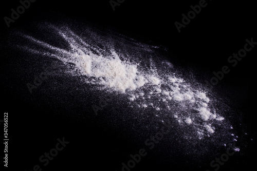 Photos White powder explosion on black background.Stopping the movement of white powder on dark background. Launched white powder splash