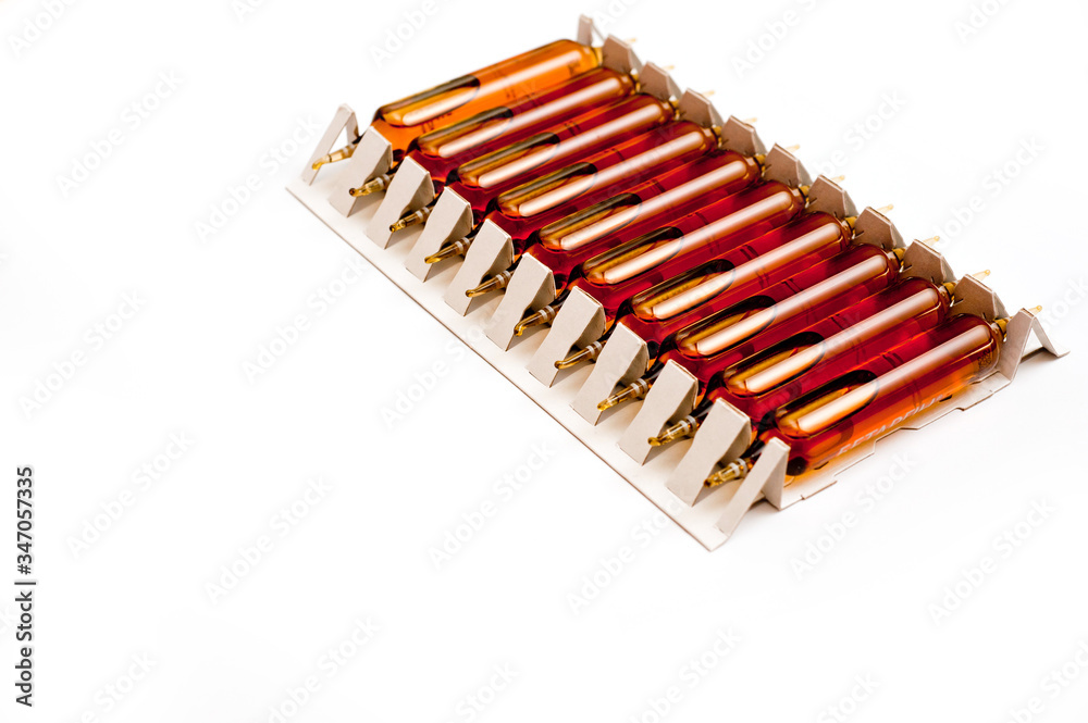 Packing of glass ampoules with a medical preparation shot on a white background. Packing of glass ampoules with a medical preparation shot on a white background.