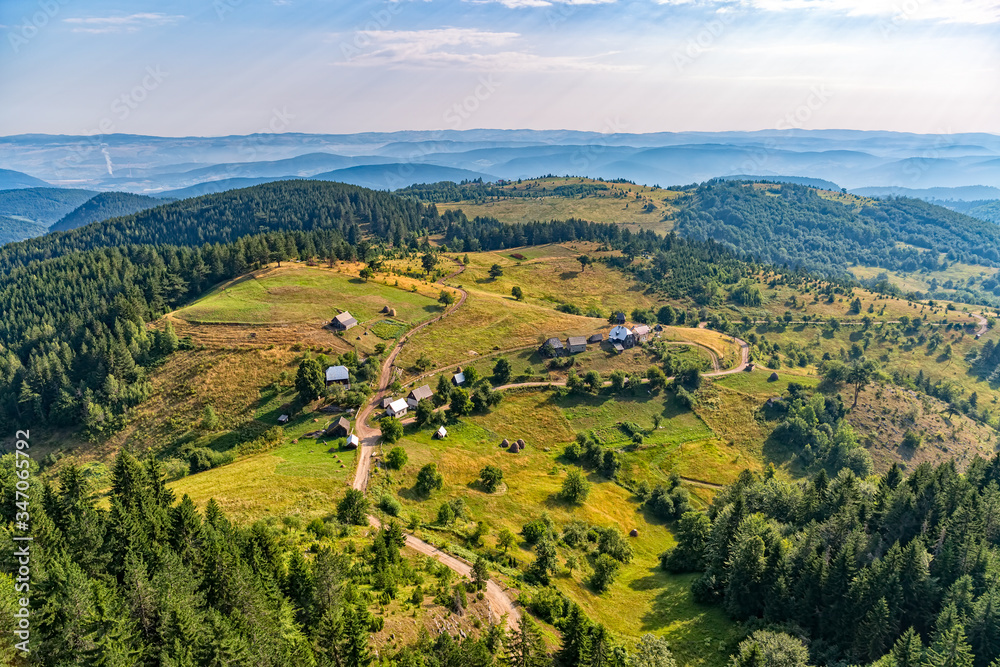 Small mountain houses on the plateau on the mountain in Montenegro on the sunny summer morning. Small mountain houses on the plateau on the mountain in Montenegro on the sunny summer morning.
