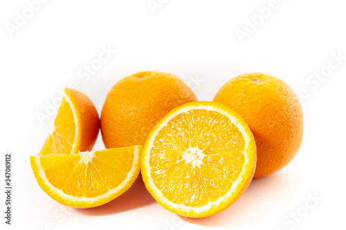 Three oranges on a white background one cut into three parts  close-up 