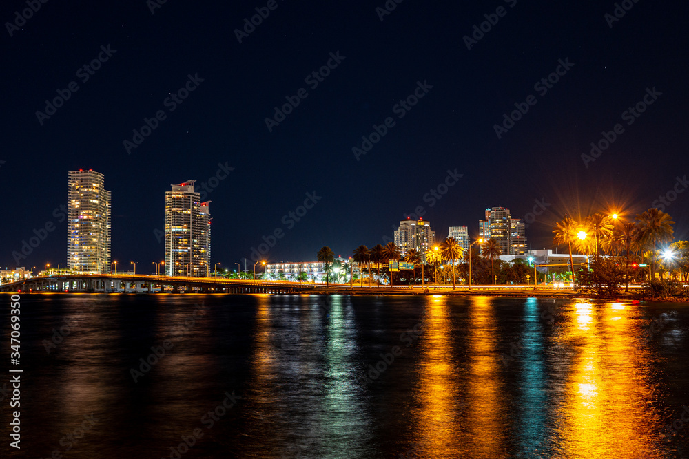 Obraz premium Miami city skyline panorama at dusk with urban skyscrapers and bridge over sea with reflection. Miami, Florida, USA skyline on Biscayne Bay. MacArthur Causeway, Watson Island, Biscayne Bay.