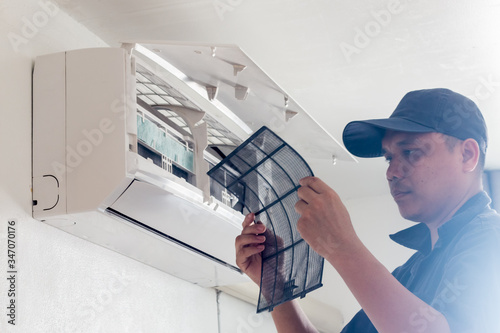  technician working service  air conditioner inroom photo