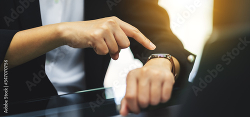 Foto A business woman pointing at a wristwatch on her working time while waiting for