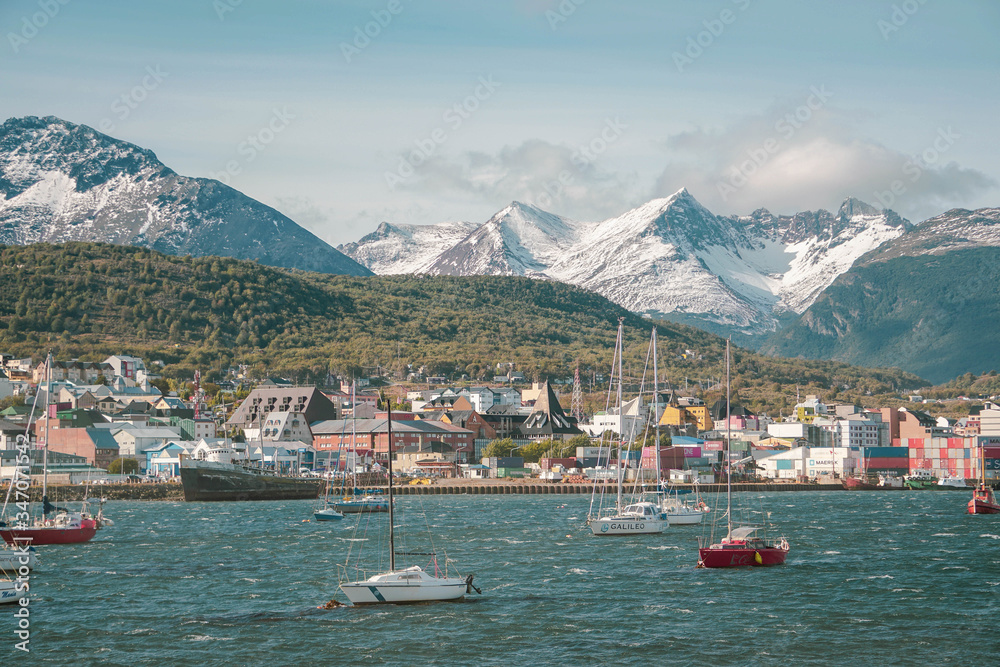 A rare view of a small city at the end of the world. Outdoor photo of a city, mountain and sailing boats during summer in Patagonia Argentina. 
Travelling, tourism and vacation concept.