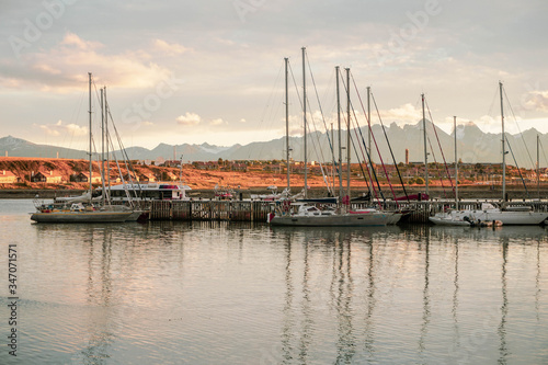 A rare view of a small city at the end of the world. Outdoor photo of a city, mountain and sailing boats during summer in Patagonia Argentina. Travelling, tourism and vacation concept.