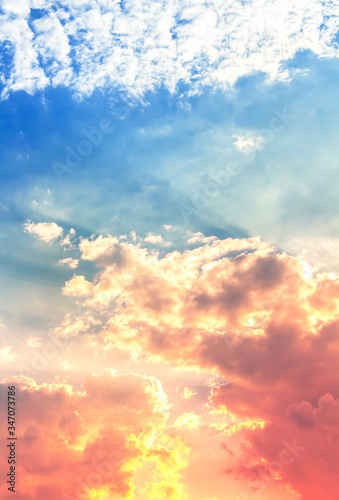 Canvas Print red and orange color light in fluffy clouds with sun rays in blue sky