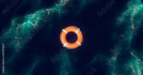 Lifebuoy floating on water. Life preserver floating in ocean. Top view of rescue ring. Life belt in a water after shipwreck. Lifebuoy in blue sea.