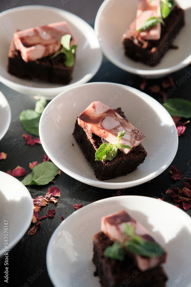 Wonderful brownie with mint leaves in white plates on banquet or event.