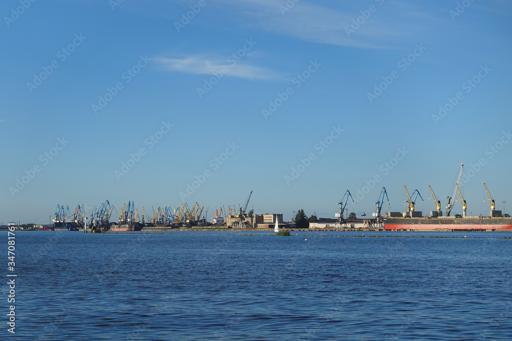 Riga, Latvia, view over the river Daugava to the shoreline with many port cranes