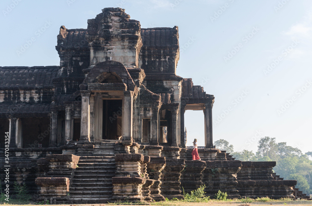 Fototapeta premium Girl walking on ruins of an old and ancient temple. 