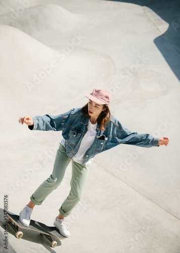 Young woman doing skateboarding trick outdoor

