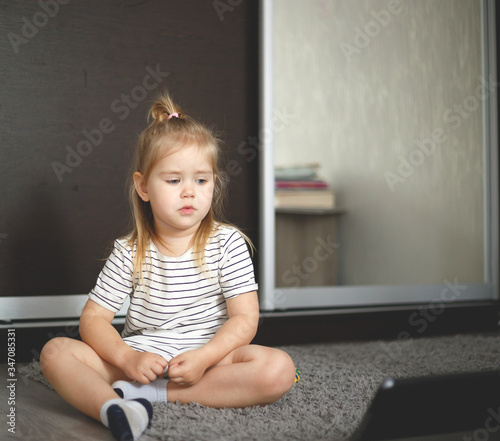 little girl at home watching tablet computer. home schooling, distance learning