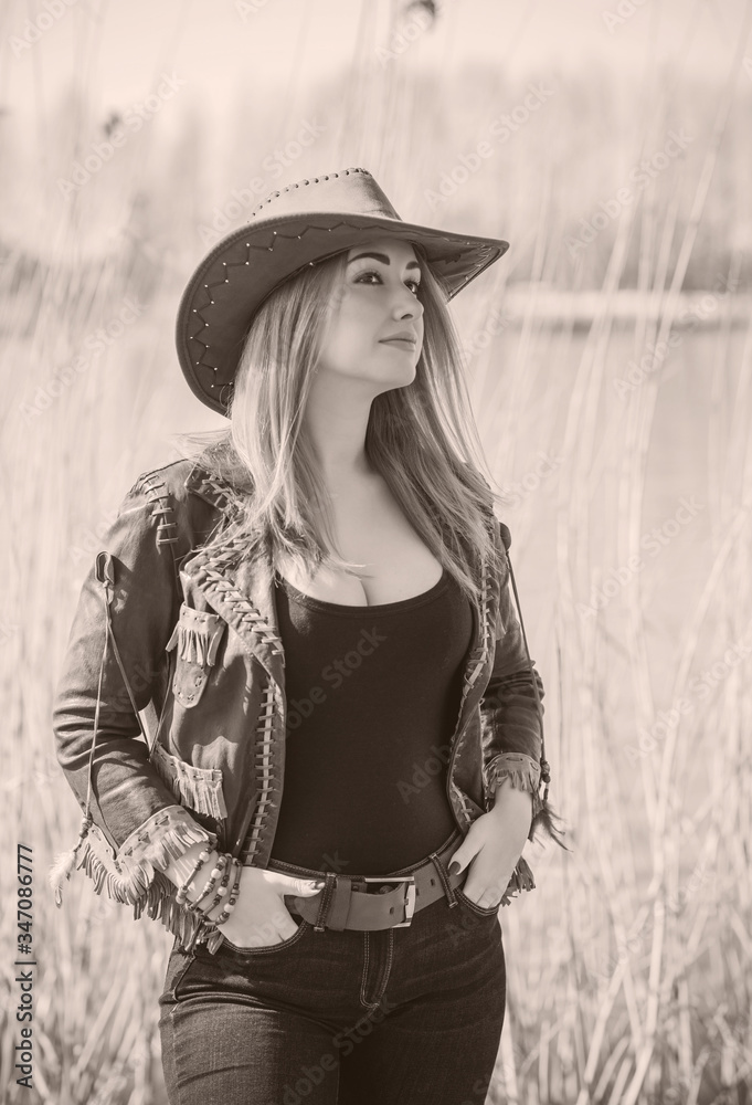 Cowgirl American style, figure woman in leather jacket, jeans and hat Cowgirl American style, figure woman in leather jacket, jeans and hat