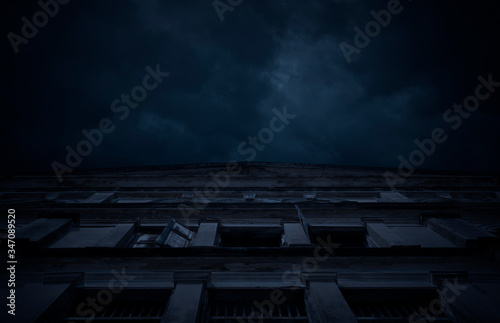 Facade of old ancient architecture building over cloudy spooky sky, Halloween mystery background