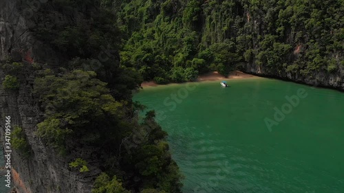 High drone view of a speed boat resting at the deserted beach at Pang Na Bay on Koh Yao Noi Island in Thailand. photo