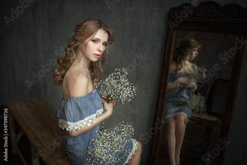 sad beautiful blonde with flowers indoors