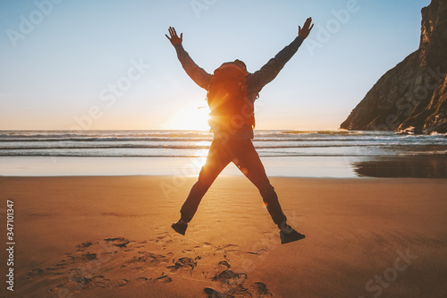 Man jumping on beach travel healthy lifestyle active vacations outdoor adventure success happy emotions traveler enjoying sunset ocean landscape