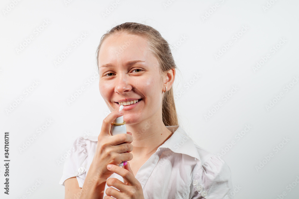 Young and attractive doctor with a throat spray isolated on white Young and attractive doctor with a throat spray isolated on white