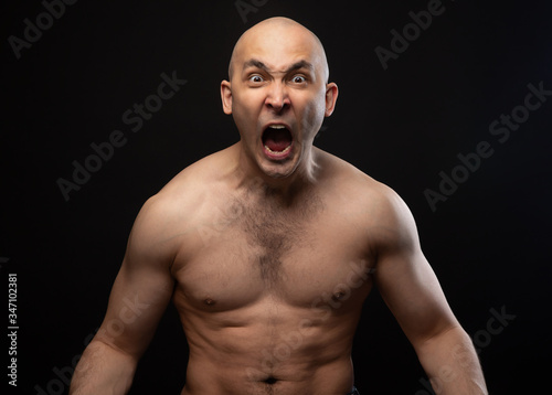 Photo of bald angry screaming man with bare shoulders