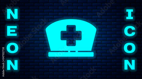 Glowing neon Nurse hat with cross icon isolated on brick wall background. Medical nurse cap sign.  Vector Illustration